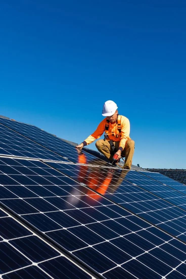Técnico instalando novos módulos solares no telhado